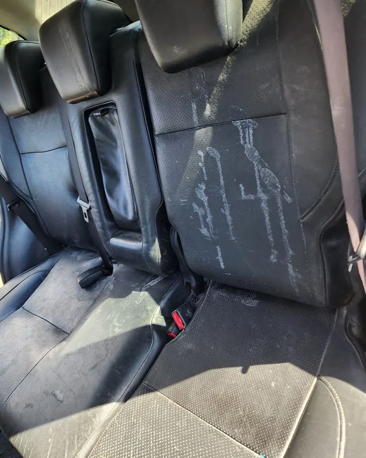 מושבי עור ברכב עם סימני נזילה לבנים לפני ניקוי