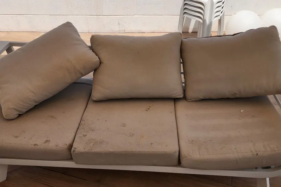 ספת חוץ עם כתמים על הכריות לפני ניקוי